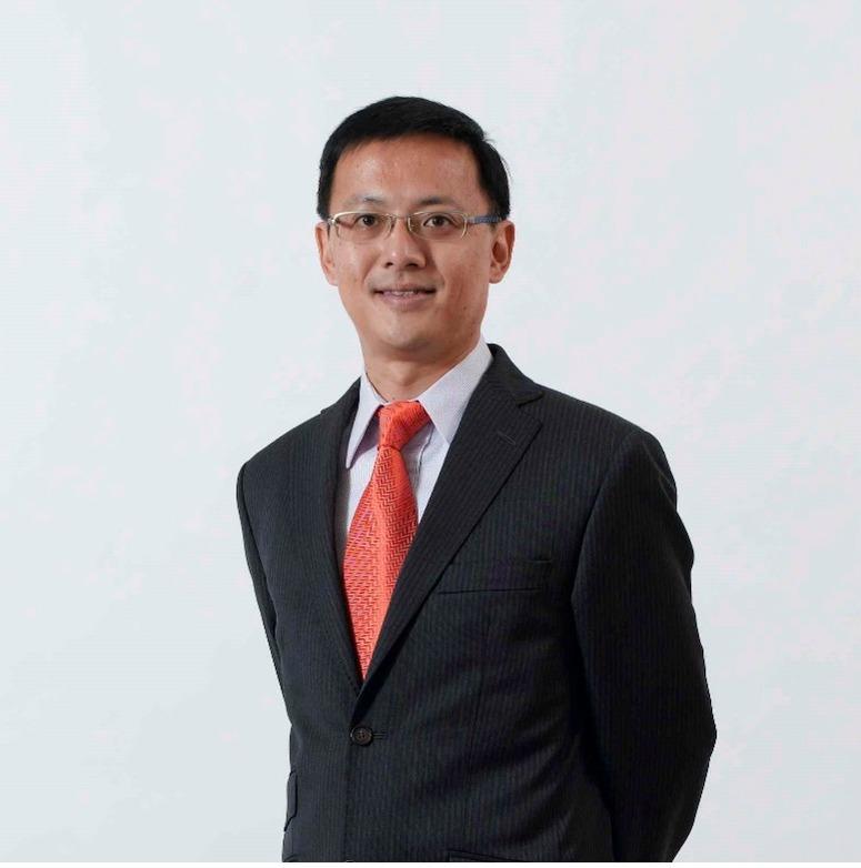 a portrait shot of a middle-aged men in business attire and red tie
